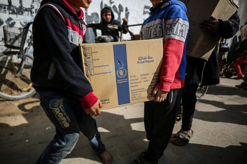 Deux personnes transportent un colis de nourriture au camp de Nusierat dans la bande de Gaza.