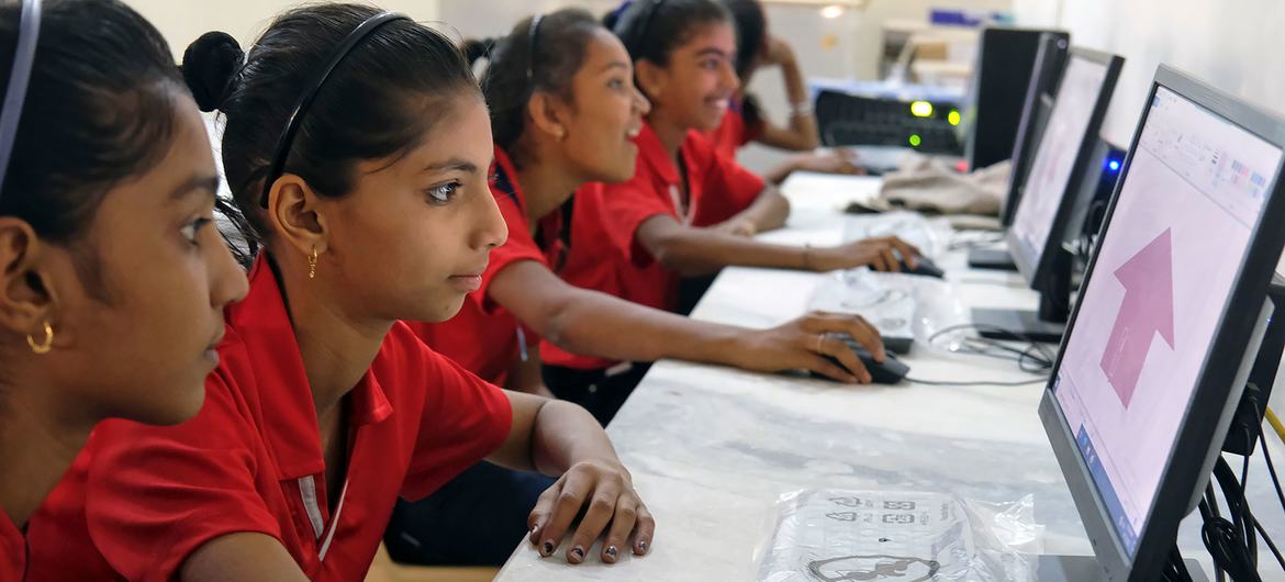 Adolescentes aprendiendo a desarrollar habilidades digitales en una escuela primaria en India.