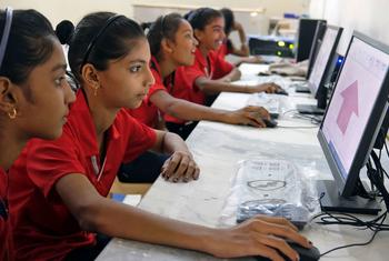 Adolescentes aprendiendo a desarrollar habilidades digitales en una escuela primaria en India.