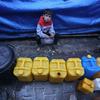 Un niño espera para recoger agua en Gaza.