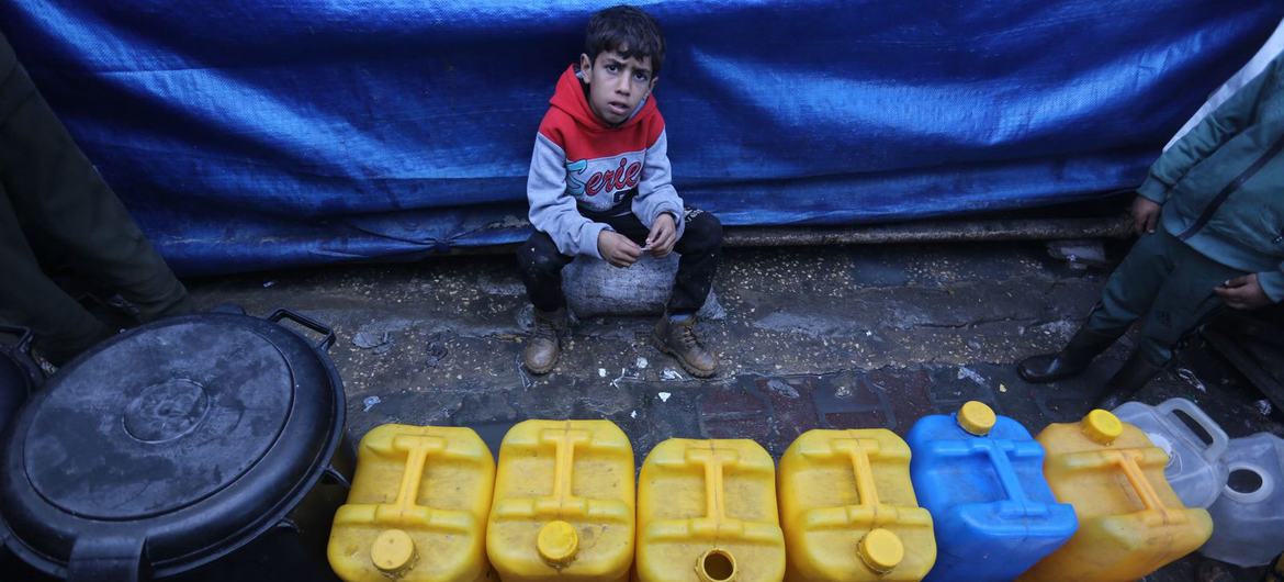 A young boy waits to collect water in Gaza.
