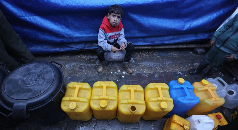 Un niño espera para recoger agua en Gaza.
