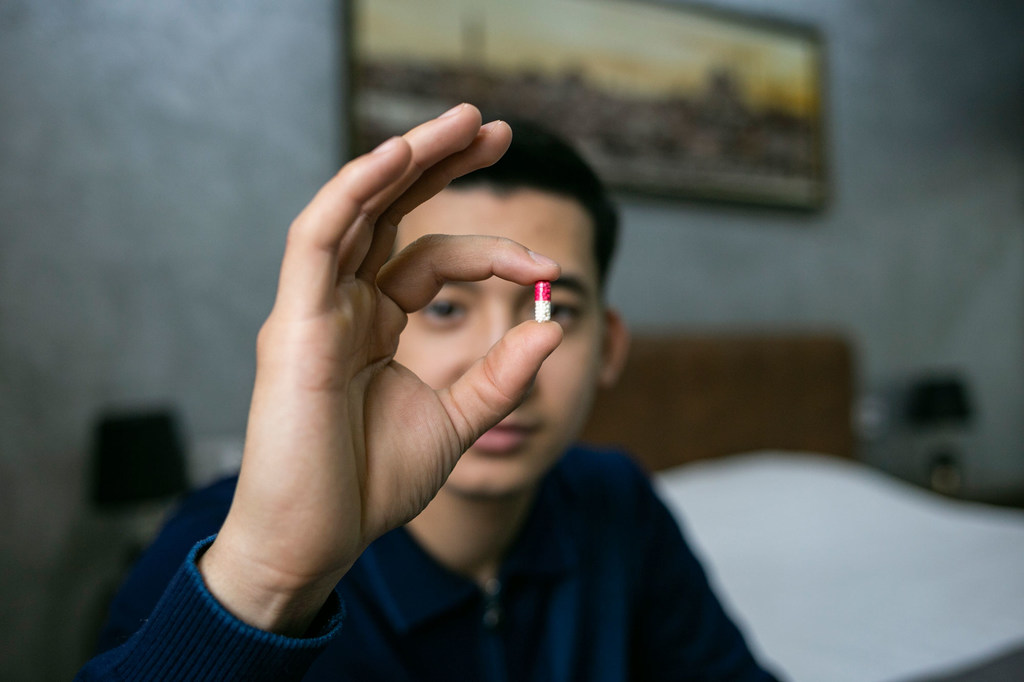 A man in Uzbekistan shows the medicine he takes to combat HIV.