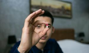 A man in Uzbekistan shows the medicine he takes to combat HIV. 