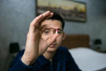 A man in Uzbekistan shows the medicine he takes to combat HIV. 