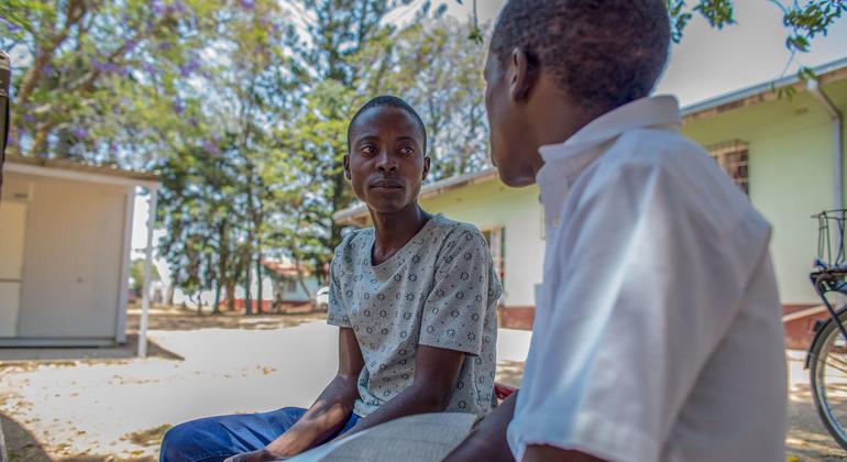Un jeune homme (à gauche), au Zimbabwe, reçoit des conseils sur le traitement contre le VIH.