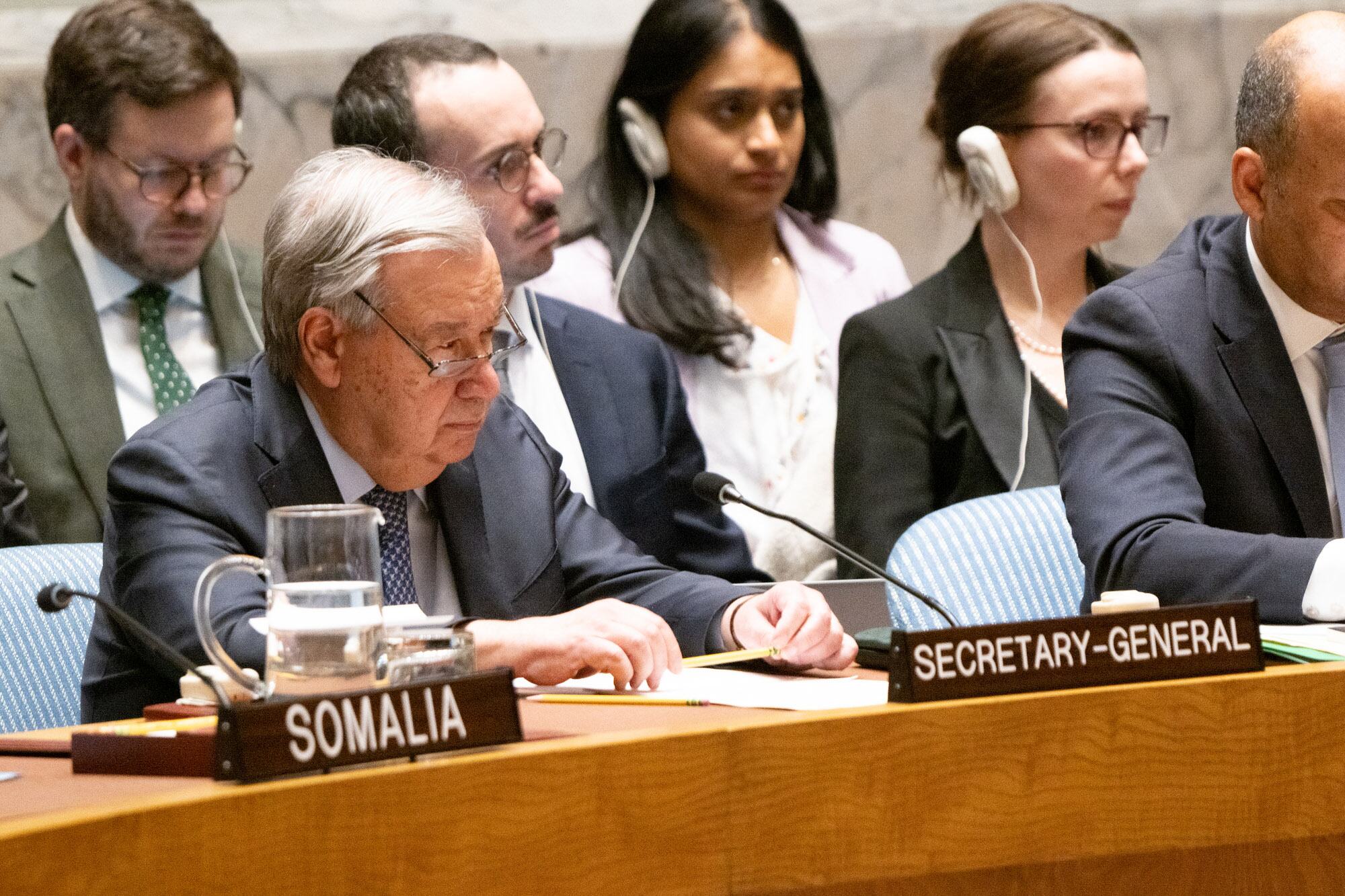 联合国秘书长在联合国安理会会议期间坐在会议桌上,前面有一张索马里海报.其他代表坐在桌子周围.