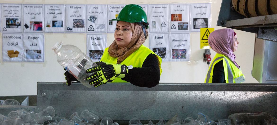 زنی پلاستیک را در یک کارخانه بازیافت در اردن دسته بندی می کند.