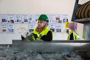 Une femme trie du plastique dans une usine de recyclage en Jordanie.