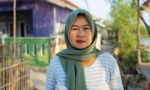 Rokaya stands in front of her house in Indramayu, West Java.