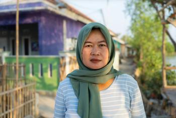 Rokaya stands in front of her house in Indramayu, West Java.