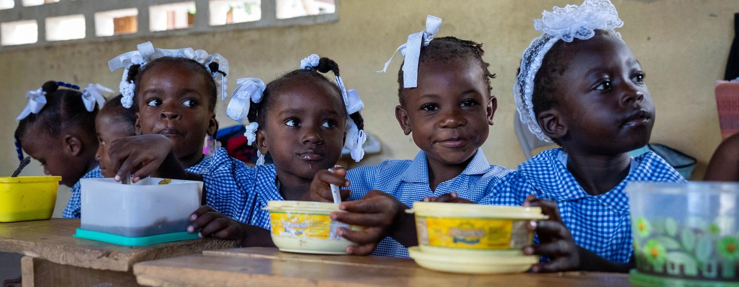 海地儿童在学校吃着联合国及其合作伙伴提供的热餐。