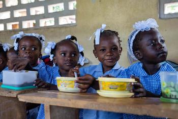 Niños de Haití comen en la escuela una comida caliente proporcionada por la ONU y sus socios. 