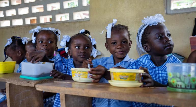 As crianças haitianas comem refeições quentes na escola fornecidas pela ONU e pelos seus parceiros. 
