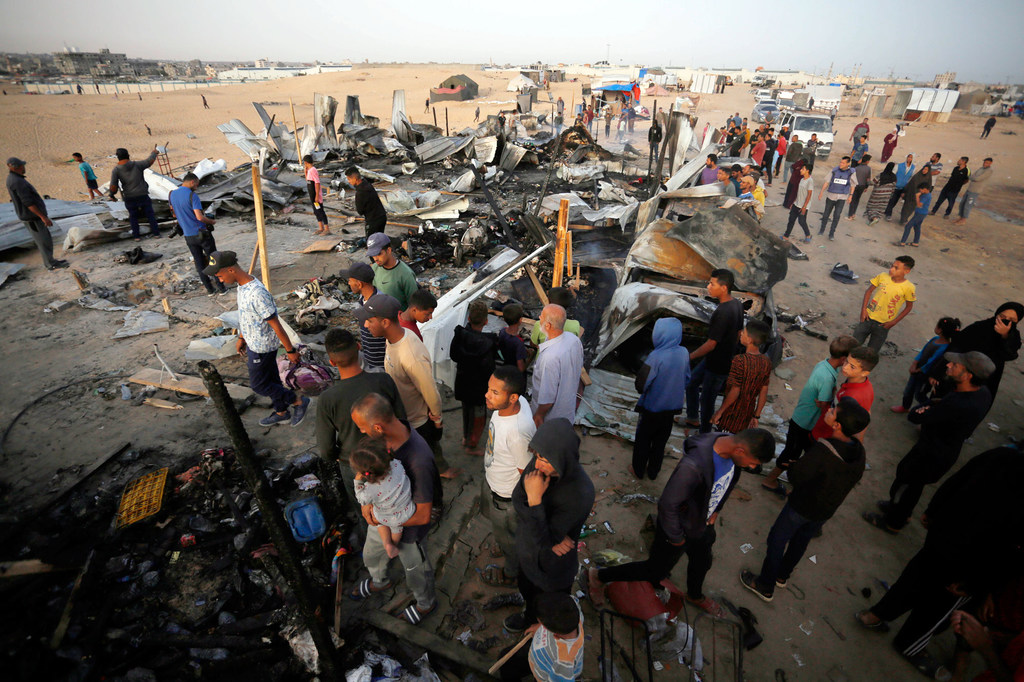 Gazans gather at a camp for displaced people which was bombed in May 2024. (file) 