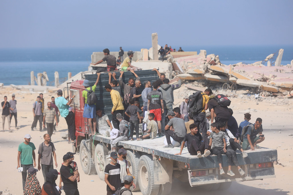 Des Gazaouis se dirigent vers un point de distribution d'aide alimentaire.