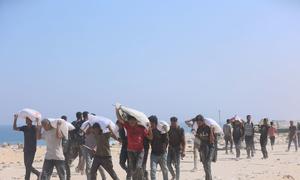 Men collect food from an aid distribution point in Gaza.