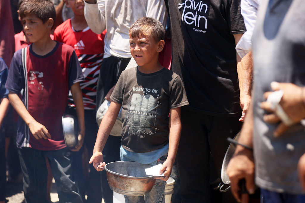 Families and children seeking food from a community kitchen in western Gaza City.