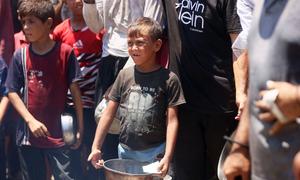 Families and children seeking food from a community kitchen in western Gaza City.