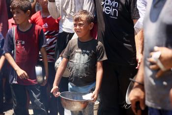 Families and children seeking food from a community kitchen in western Gaza City.