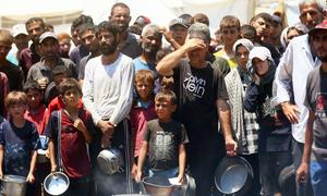 Gente buscando comida en una cocina comunitaria de la ciudad de Gaza.