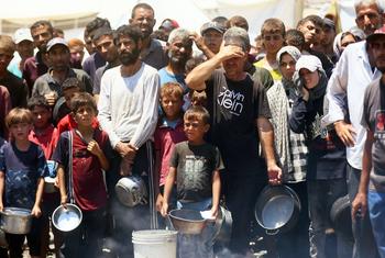 Gente buscando comida en una cocina comunitaria de la ciudad de Gaza.