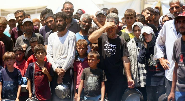 Gente buscando comida en una cocina comunitaria de la ciudad de Gaza.