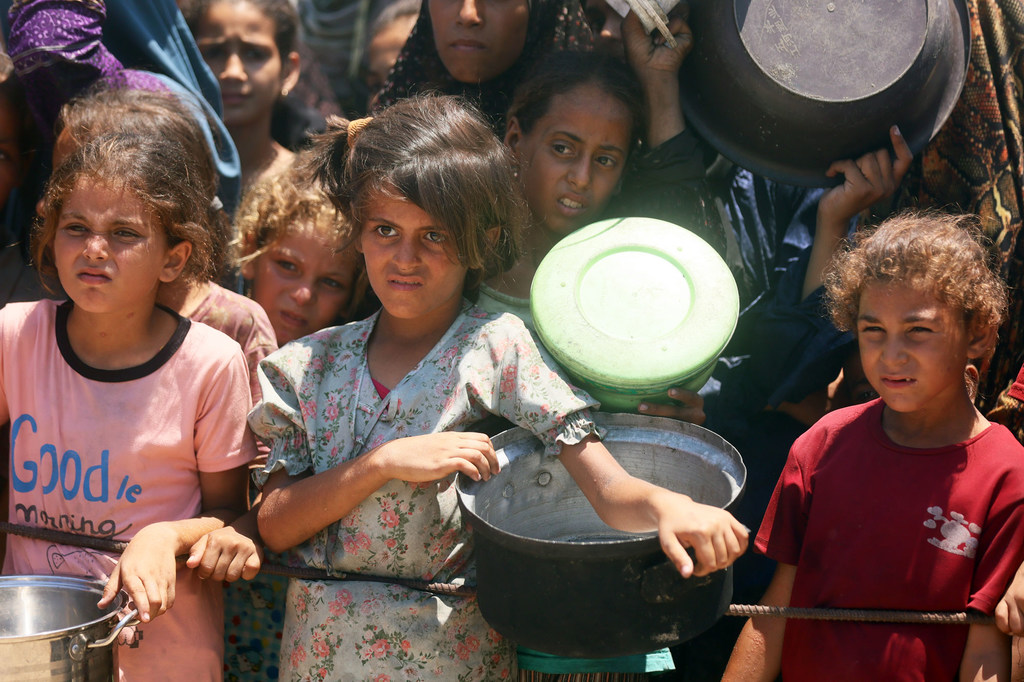 Des enfants attendent de la nourriture dans une cuisine communautaire de l'ouest de la ville de Gaza.