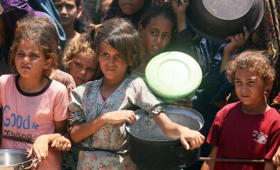 Des enfants attendent de la nourriture dans une cuisine communautaire de l'ouest de la ville de Gaza.