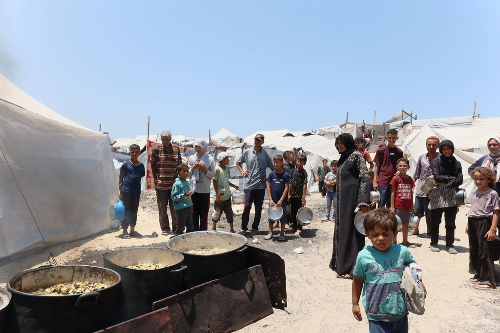 Des familles cherchent de la nourriture dans une cuisine communautaire à l'ouest de la ville de Gaza.