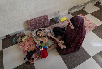 Un jeune homme de 20 ans souffrant de malnutrition sévère et de paralysie cérébrale reçoit l'attention d'une femme.