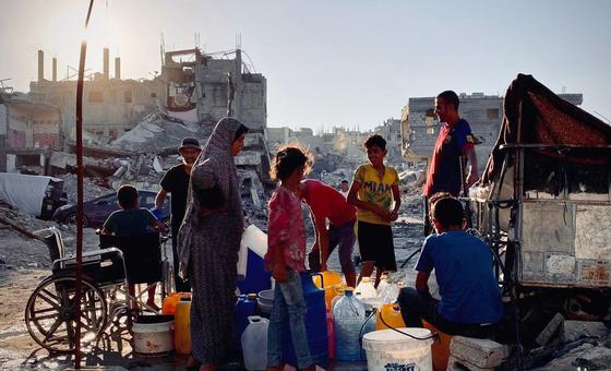 أناس يجمعون المياه في دير البلح، غزة.