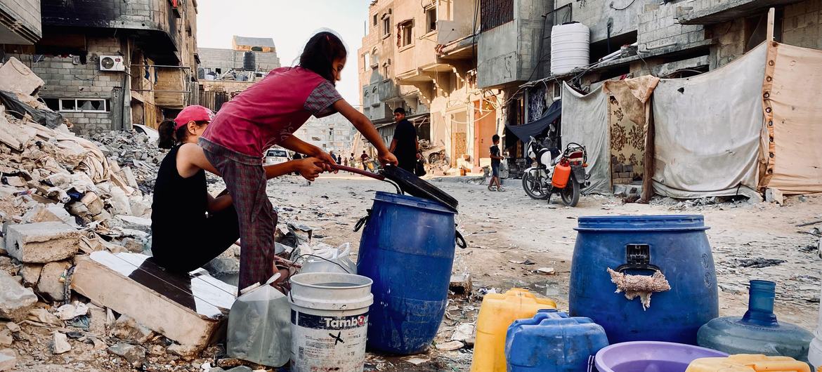 Children collect water in Gaza.