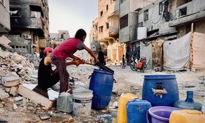 Children collect water in Gaza.