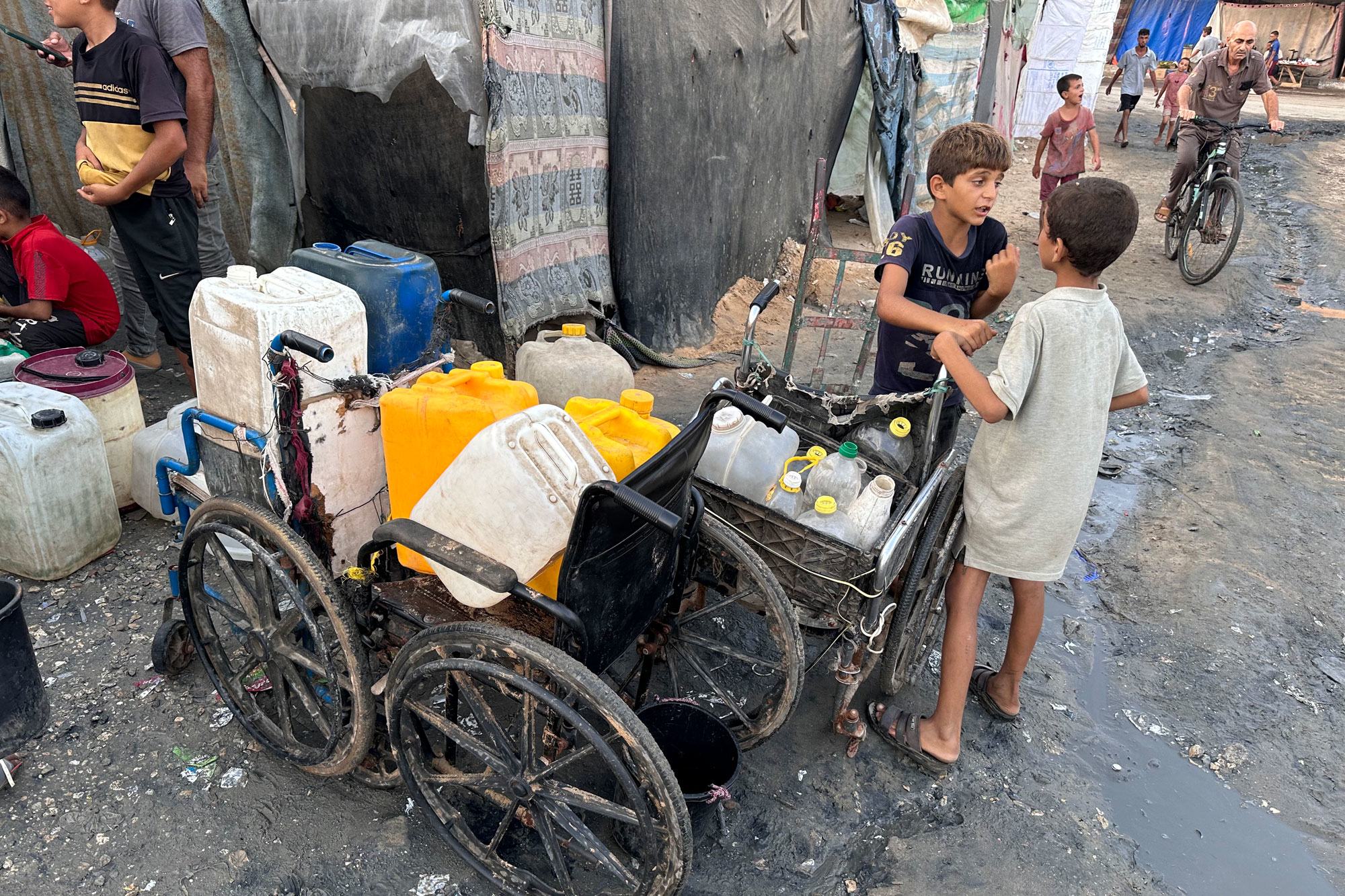 أطفال يجمعون المياه في قطاع غزة.