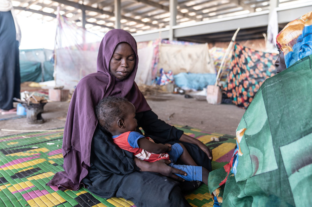 A mother looks after her child at a camp for displaced people in Gedaref, Sudan, after fleeing her home.