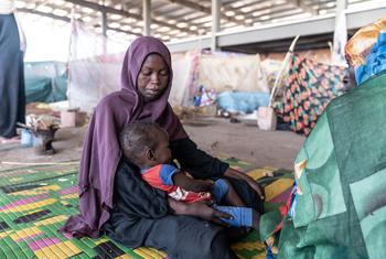 A mother looks after her child at a camp for displaced people in Gedaref, Sudan, after fleeing her home.