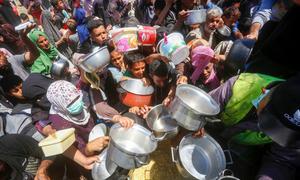 People clamour for food in Gaza.