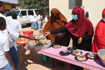 WFP समर्थित स्कूल फीडिंग कार्यक्रम के हिस्से के रूप में गारोवे, सोमालिया में भोजन परोसते हुए.है।