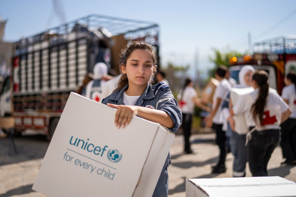 Une jeune fille au Liban porte des fournitures distribuées par l'UNICEF.