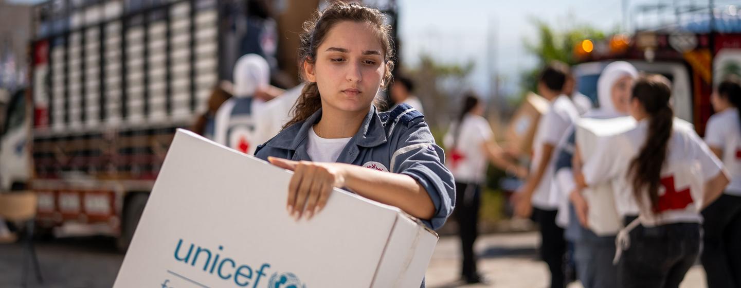 Une jeune fille au Liban porte des fournitures distribuées par l'UNICEF.