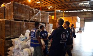 World Food Programme workers discuss the distribution of aid in a warehouse in Jamaica.