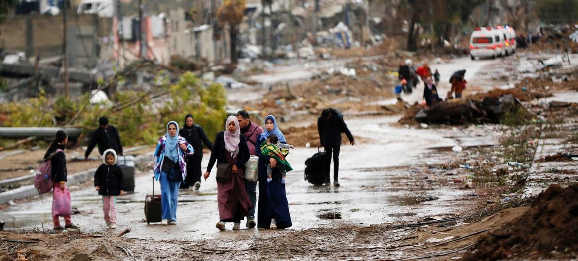 Desplazados caminan desde el norte de Gaza hacia el sur, mientras las ambulancias se dirigen en la otra dirección. 