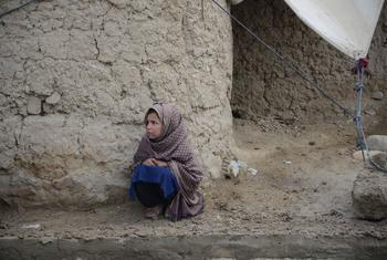 Une jeune fille se blottit contre le froid dans un camp pour personnes déplacées en Afghanistan.