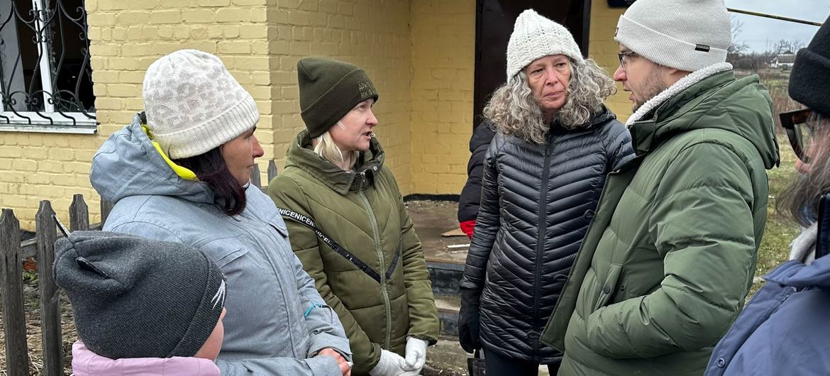 The Humanitarian Coordinator and Head of the United Nations in Ukraine, Denise Brown (centre right), talks to residents of Hroza on the frontline in Ukraine.