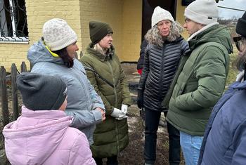 Denise Brown, UN Humanitarian Coordinator in Ukraine (centre right), spoke with residents in Hroza in December.