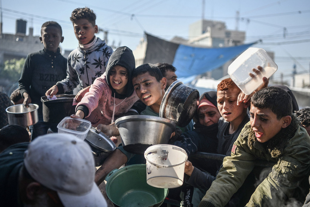 أشخاص من مختلف الإعمار يتزاحمون طلبا للطعام في مدينة رفح جنوب قطاع غزة.