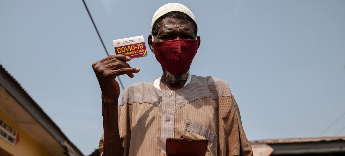 Un hombre de 76 años muestra su tarjeta de vacunación contra la COVID-19 en Kasoa, Ghana.