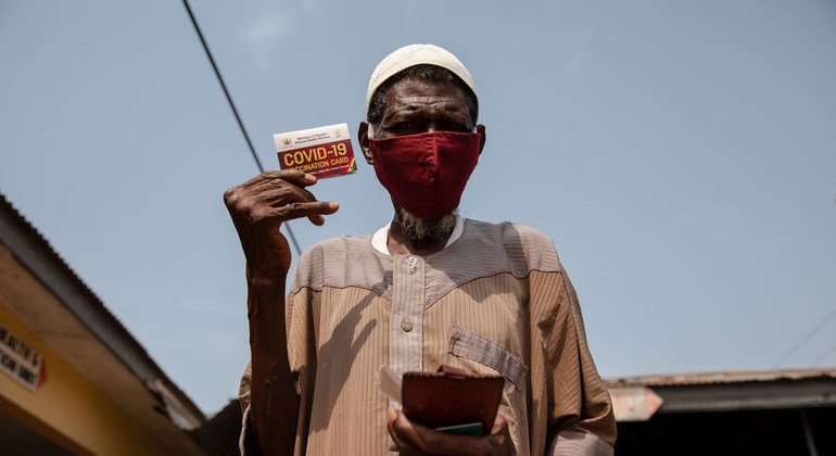 在加纳的卡索阿，一名76岁的老人在接种新冠疫苗后展示了他的疫苗接种卡。