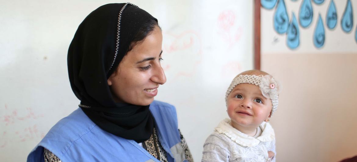 Un bebé es atendido por una trabajadora sanitaria de UNRWA (archivo).
